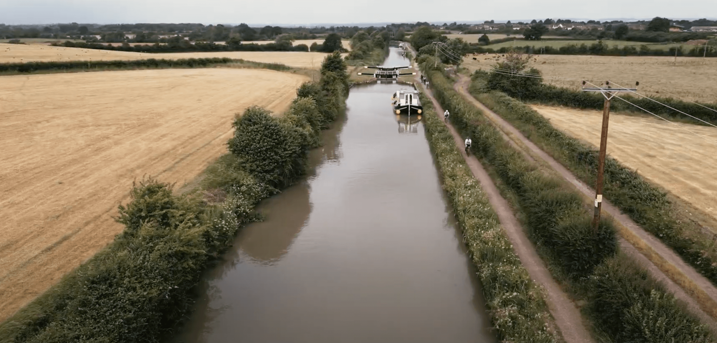 Aerial Shot of Houseboats on the River with Cyclists